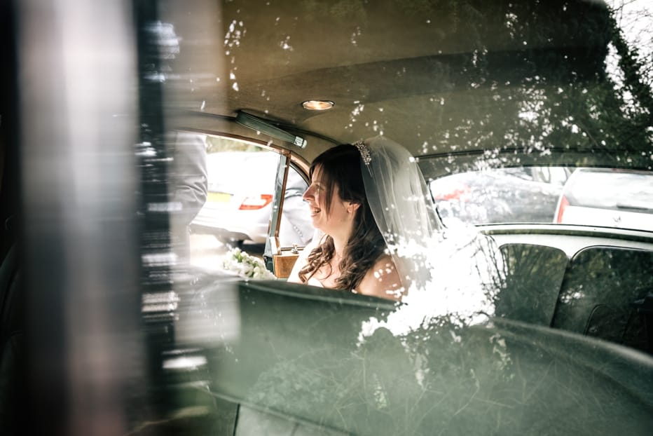 bride smiling in wedding car