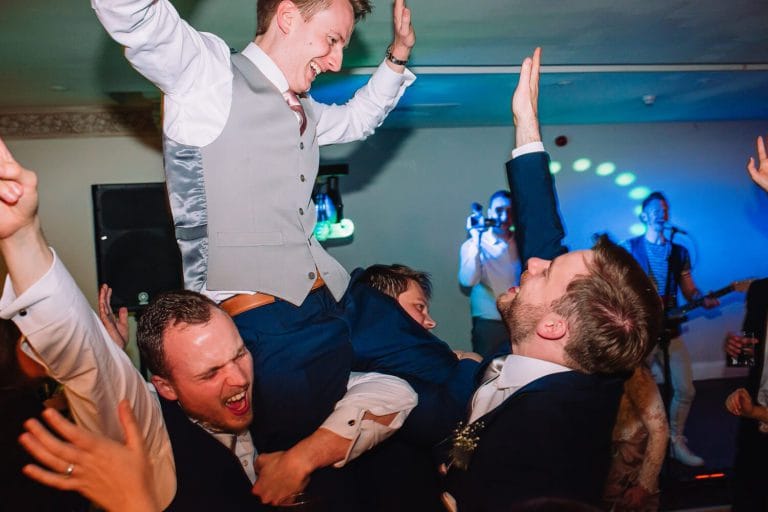 groom on shoulders at wedding